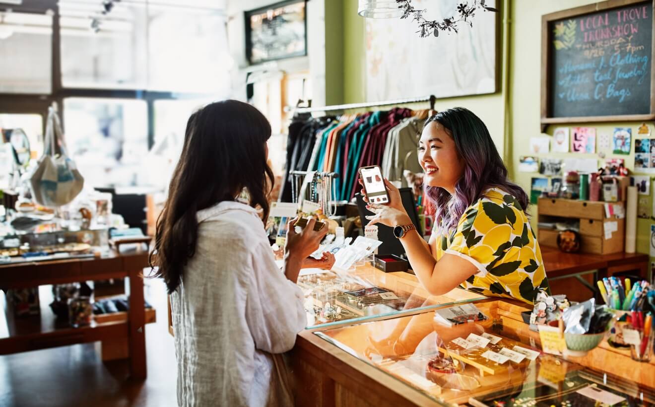 Retail business owner using their reliable Wi-Fi to show a customer products online