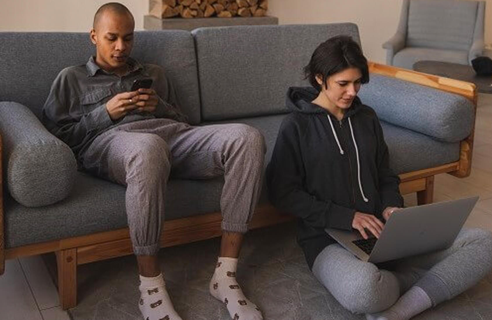 Couple at home on phone and laptop